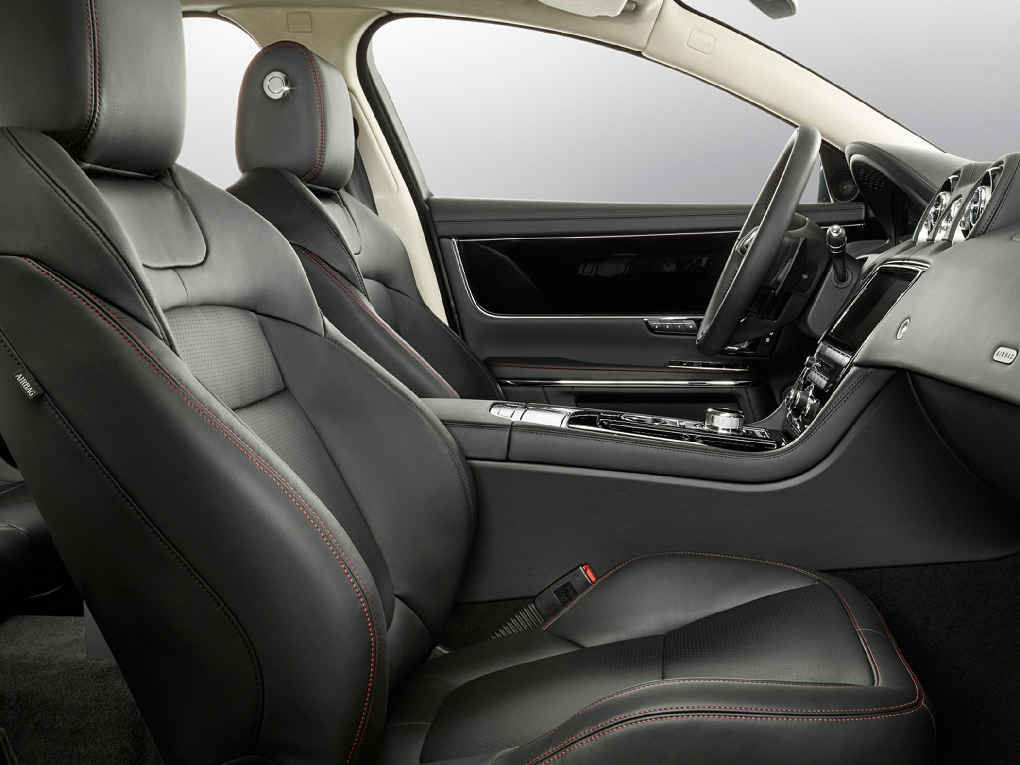 Black leather luxury seats with red stitching and modern dashboard interior
