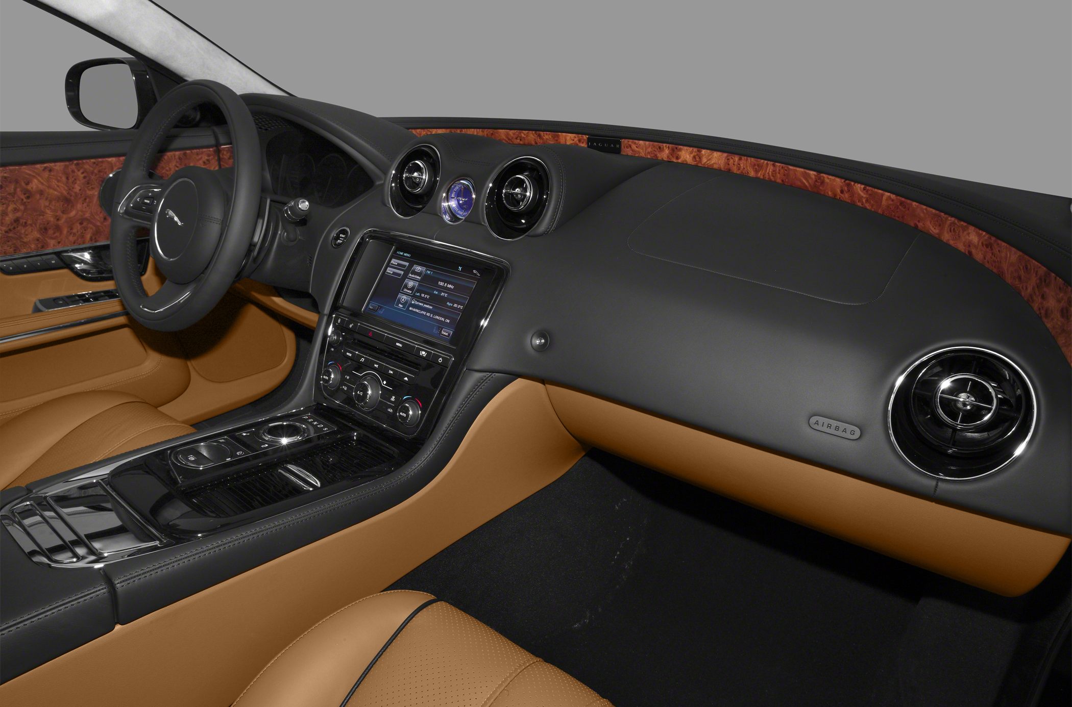 Luxury car interior with wood trim, leather seats, and advanced center console