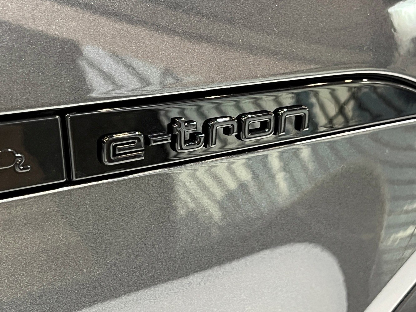 Close-up of the e-tron electric badge in glossy black trim