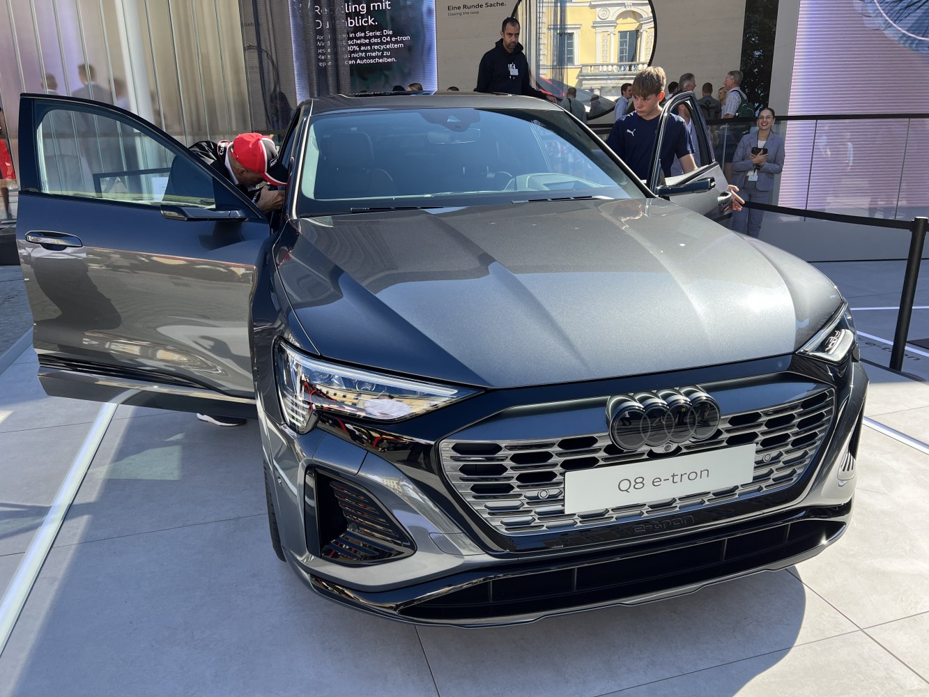 Front view of electric SUV with detailed grille, LED headlights, and open doors