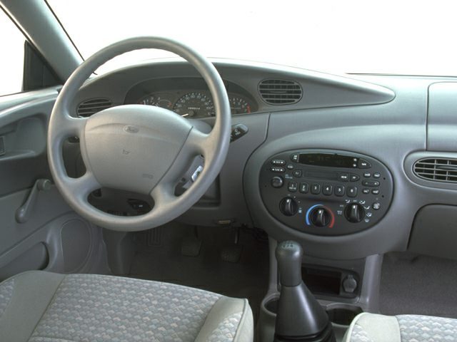Steering wheel, dashboard with instrument cluster and center console controls.