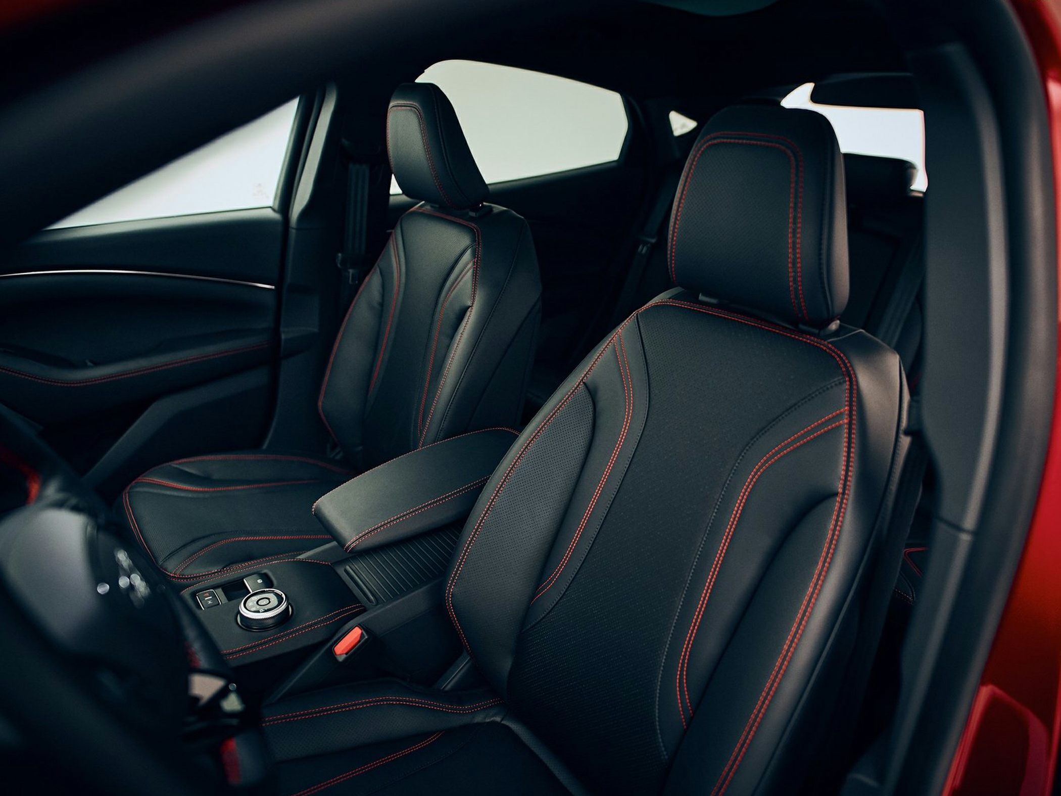 Black car seats with red contrast stitching and modern center console