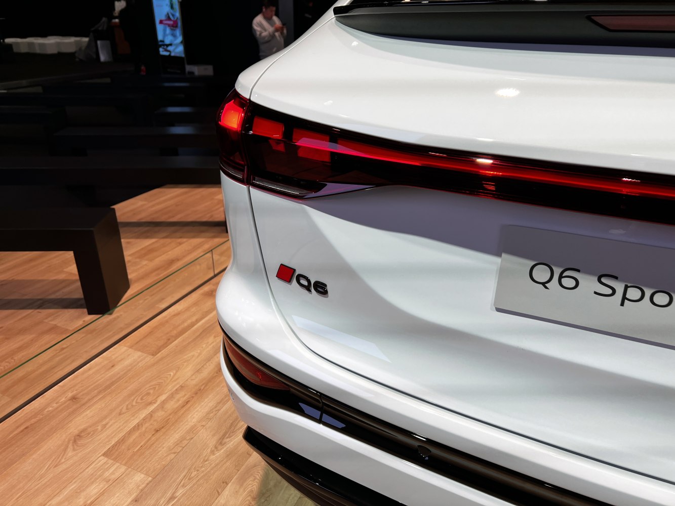 Close-up of rear LED tail light and Q6 badge on white SUV rear