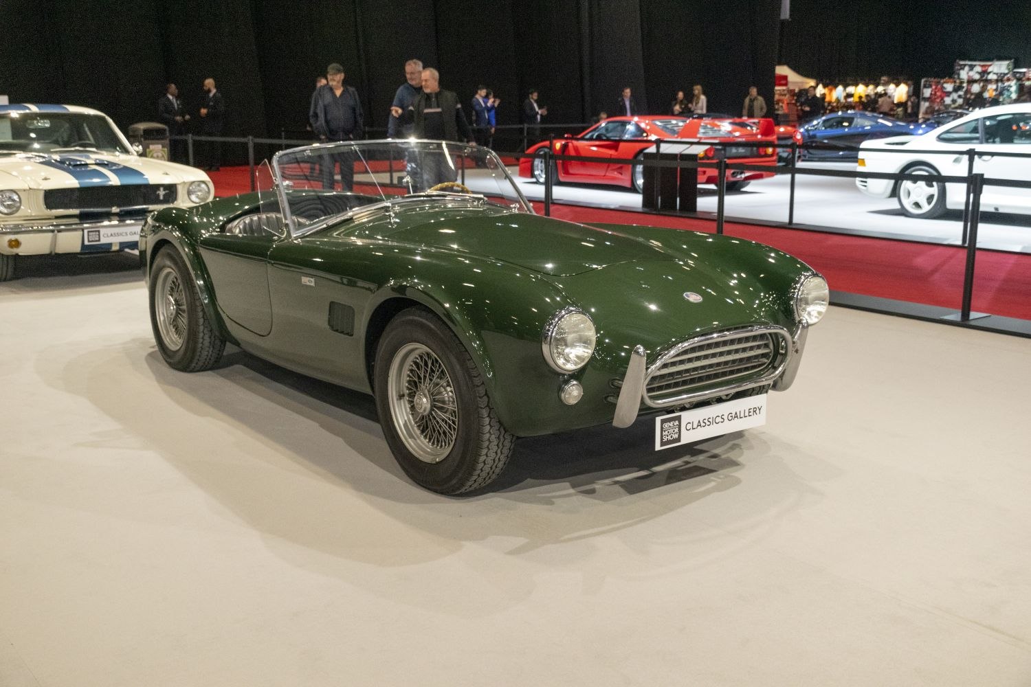 Open top vintage roadster with wire-spoke wheels and round headlights