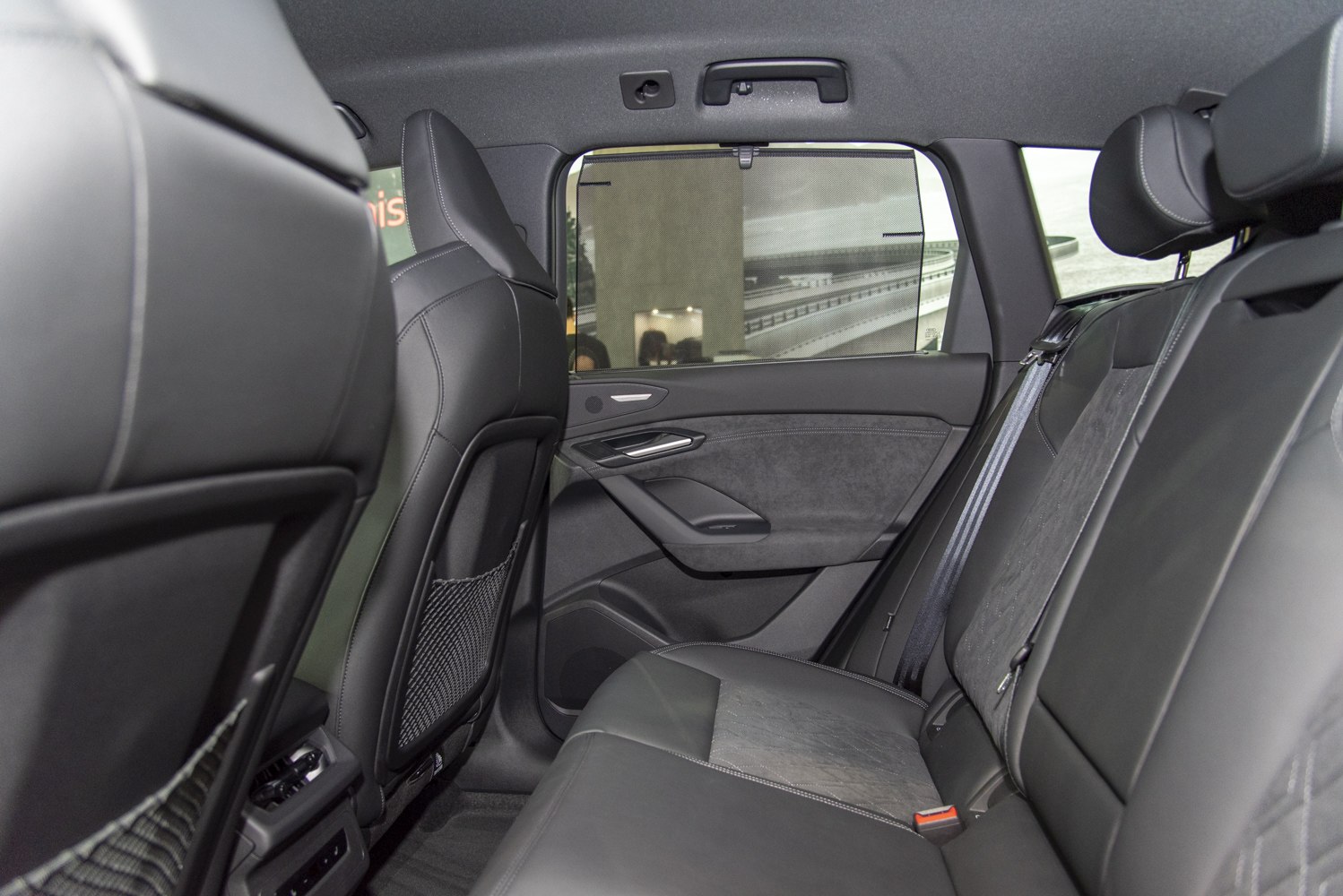 Premium rear seats with detailed stitching and door panel with window shade