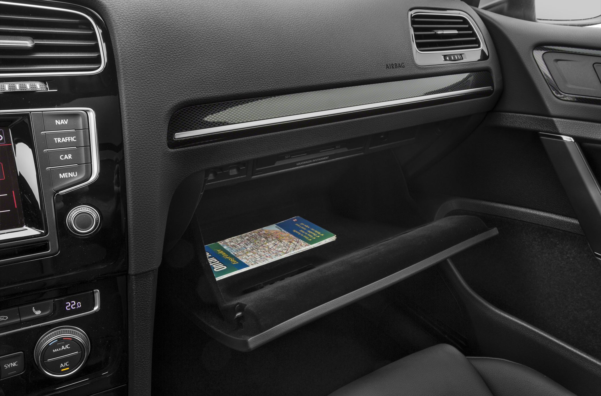 Dashboard controls and open glovebox with a map inside