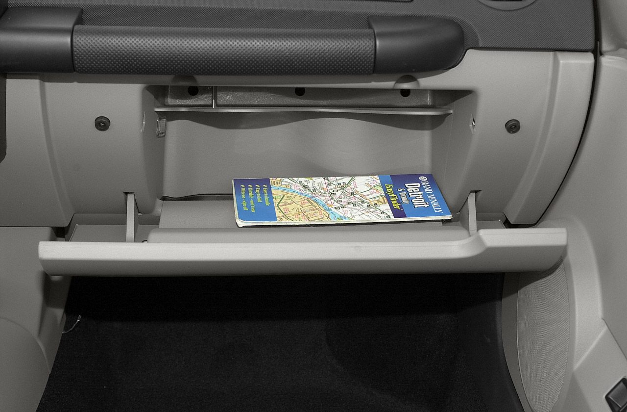 Open glove box with a map inside in car interior