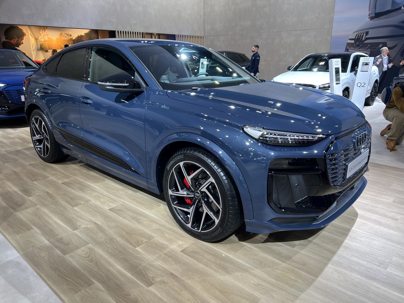 Front-side view of sportback EV with narrow LED headlights and multi-spoke alloy wheels