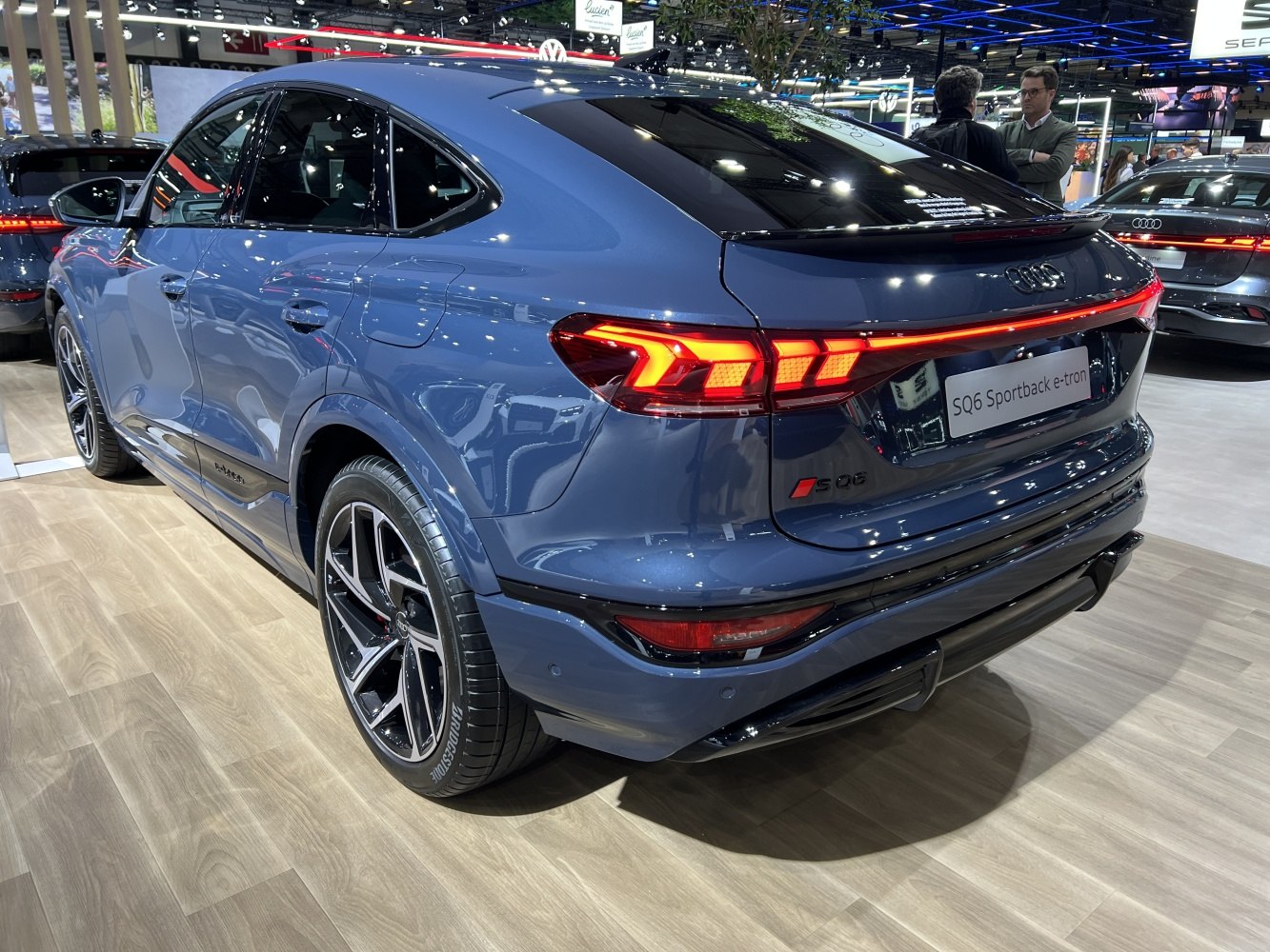 Rear and side view of a blue electric SUV with sleek lines and LED tail lights.