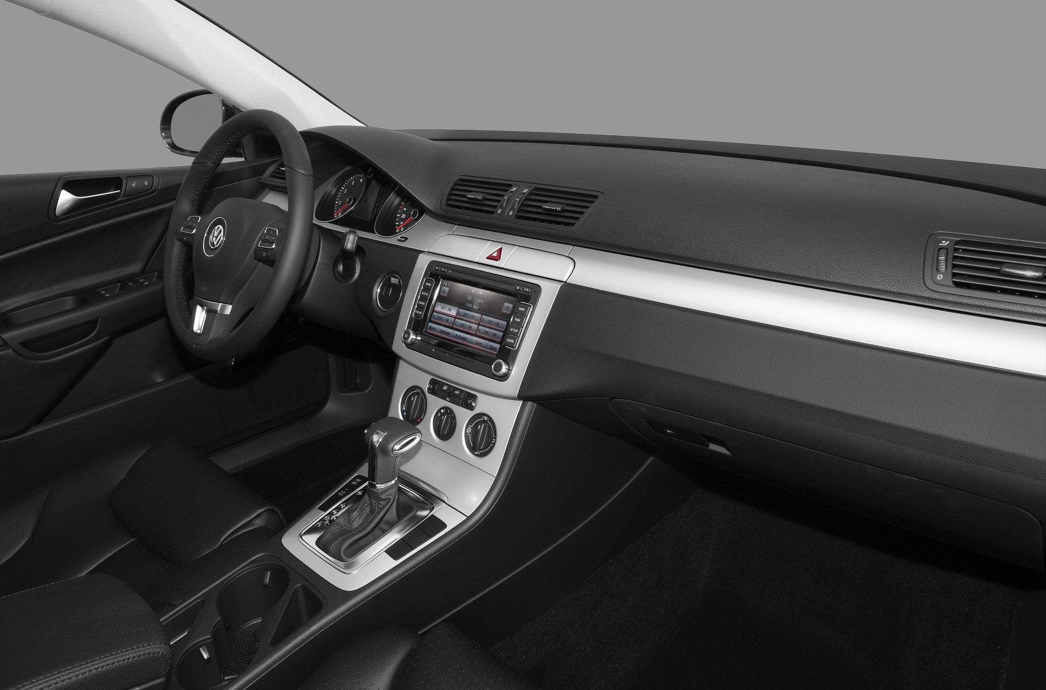Car interior with dashboard, steering wheel, infotainment, and gear shift