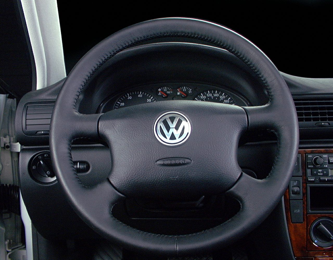 Leather-wrapped steering wheel with gauge cluster and dashboard controls