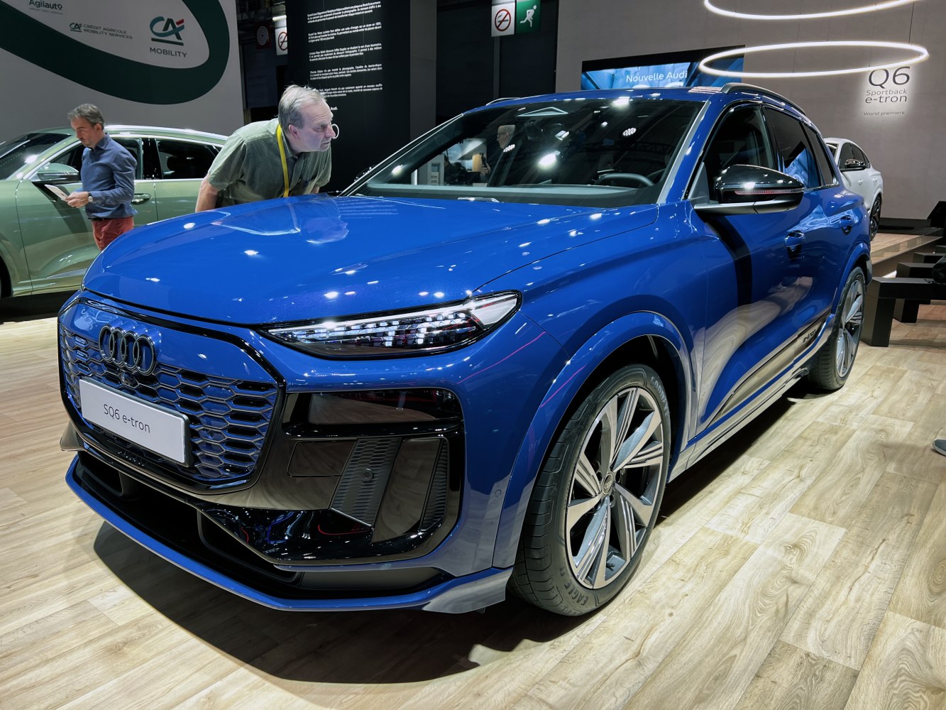 Blue electric luxury SUV with sharp LED headlights and aerodynamic styling