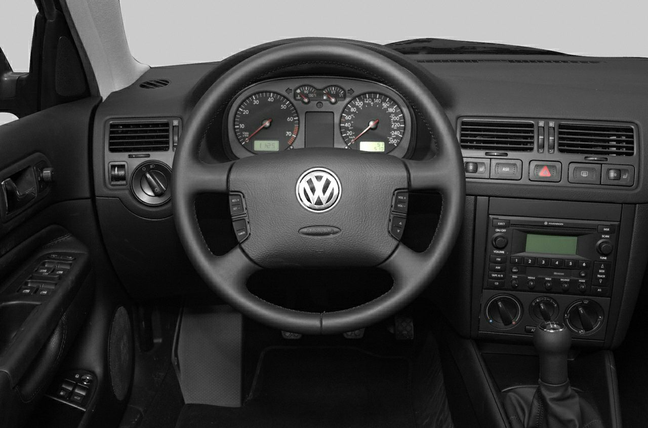 Steering wheel, instrument cluster, and center console with manual gear shift.