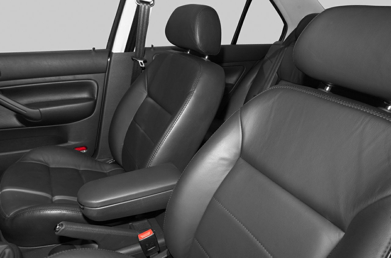Close-up of black leather front seats and armrest in car interior