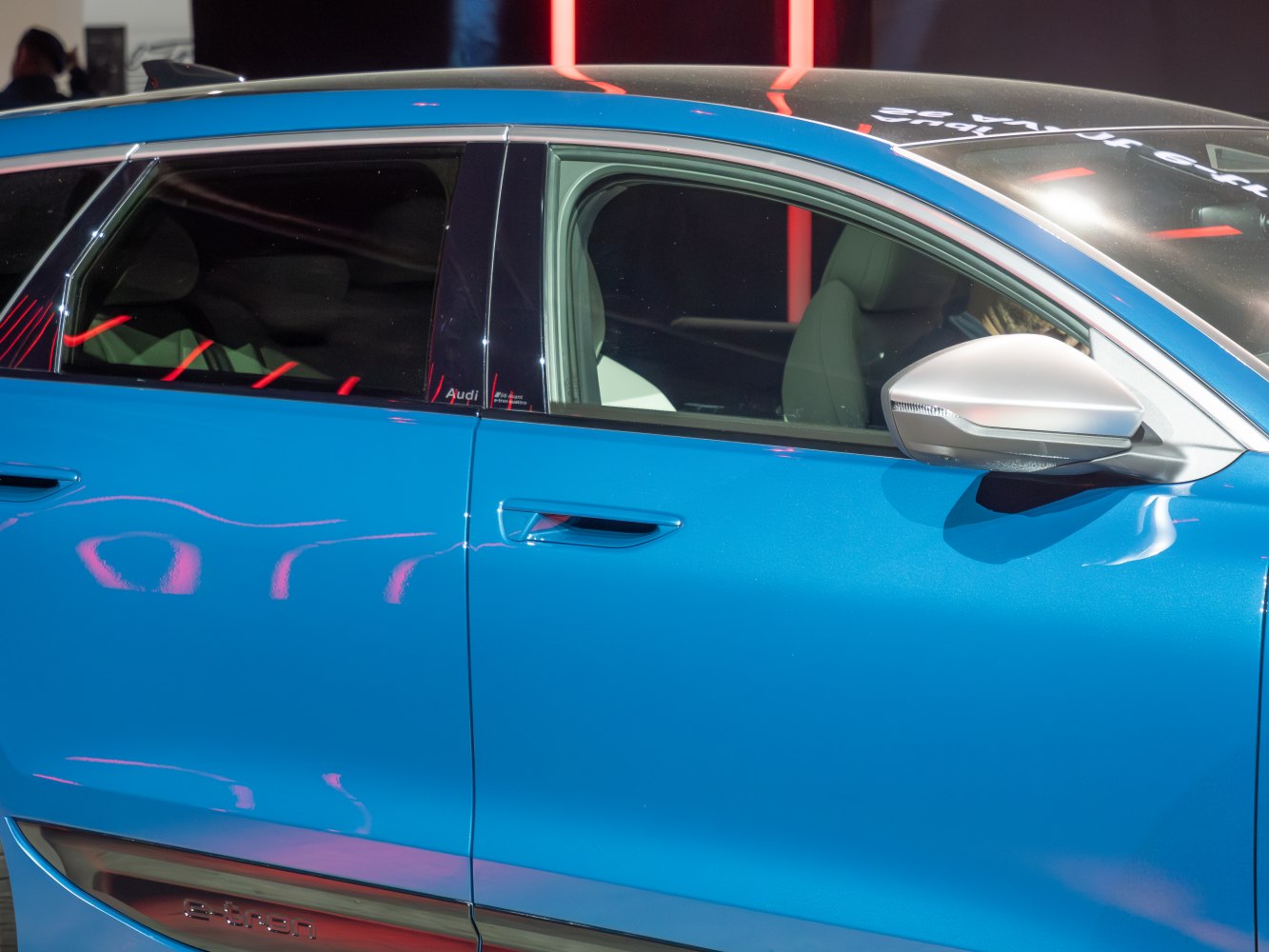 Side door and silver side mirror of a blue vehicle