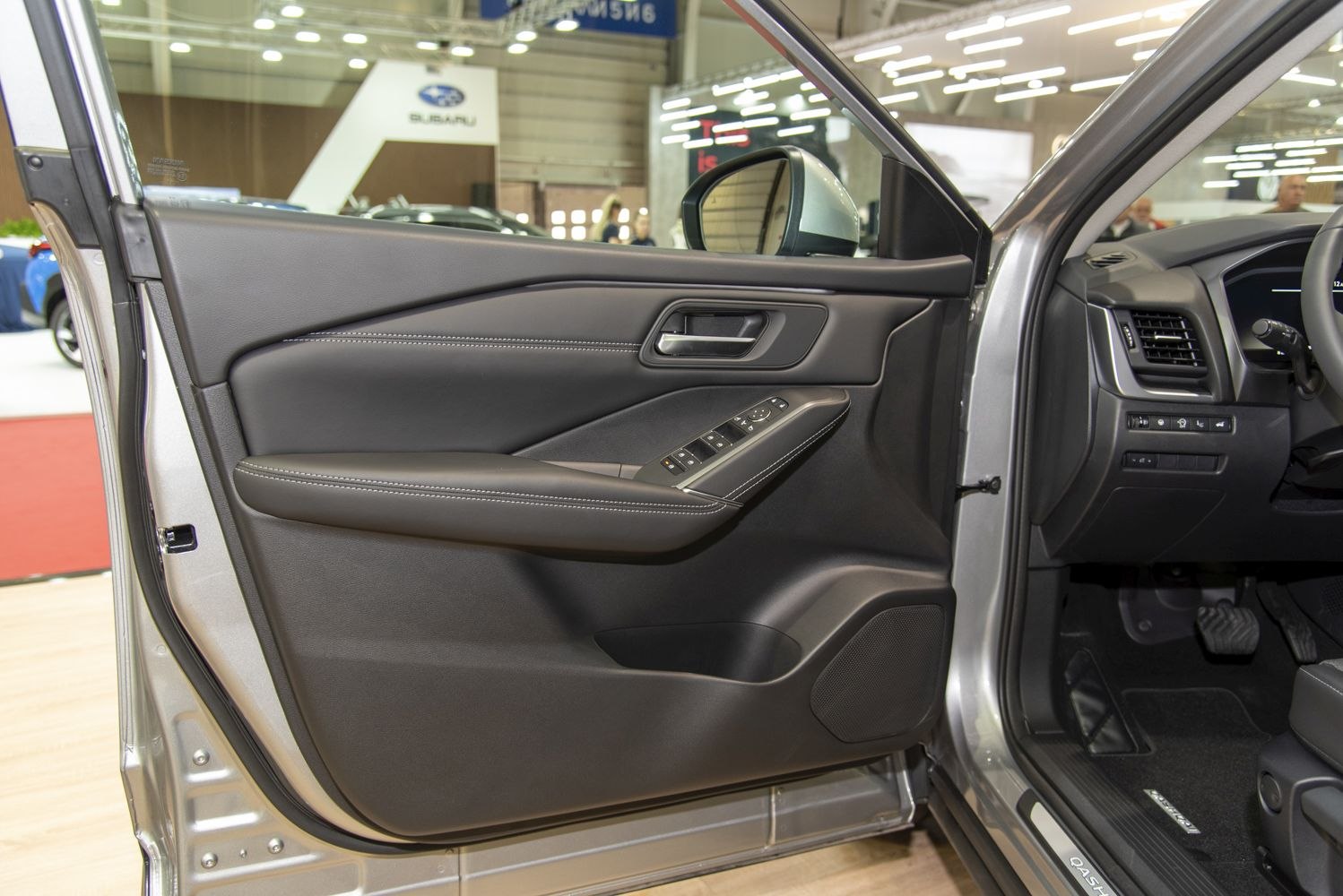 Driver side interior door panel with window controls and armrest