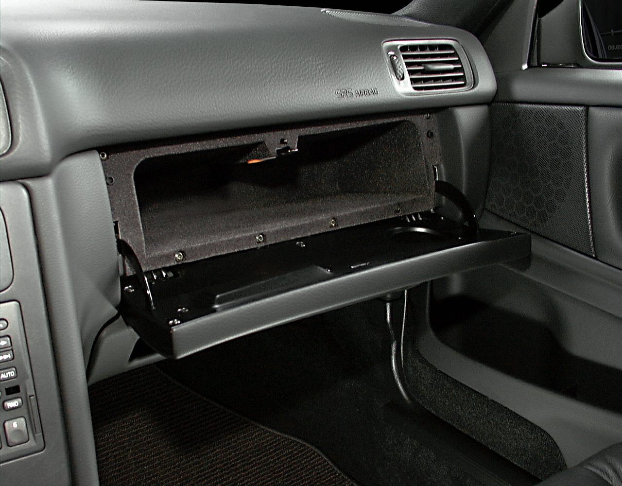 Open glove compartment with dashboard air vent and speaker grille