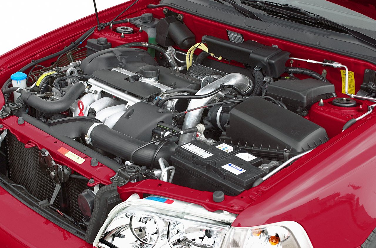 Detailed engine bay of a classic compact sedan from the 90s.