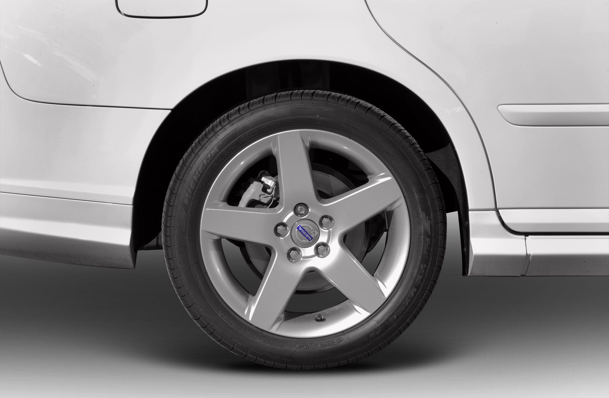 Close-up of a 5-spoke alloy wheel and tire on a vehicle rear side panel.