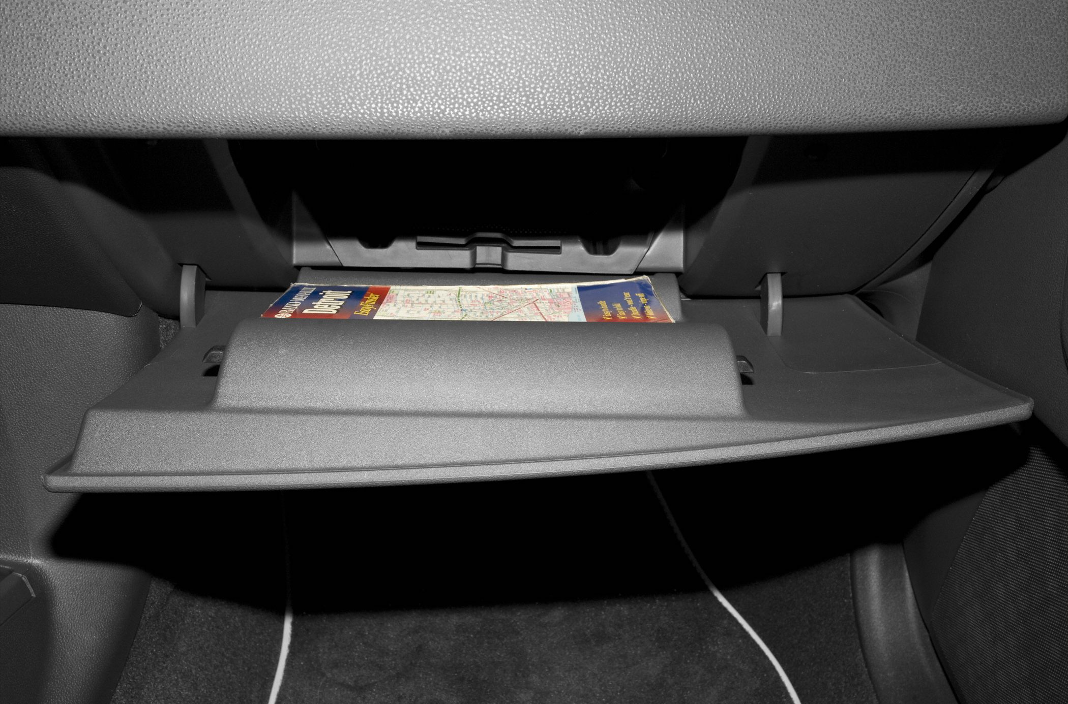 Open glovebox with a map inside in vehicle interior