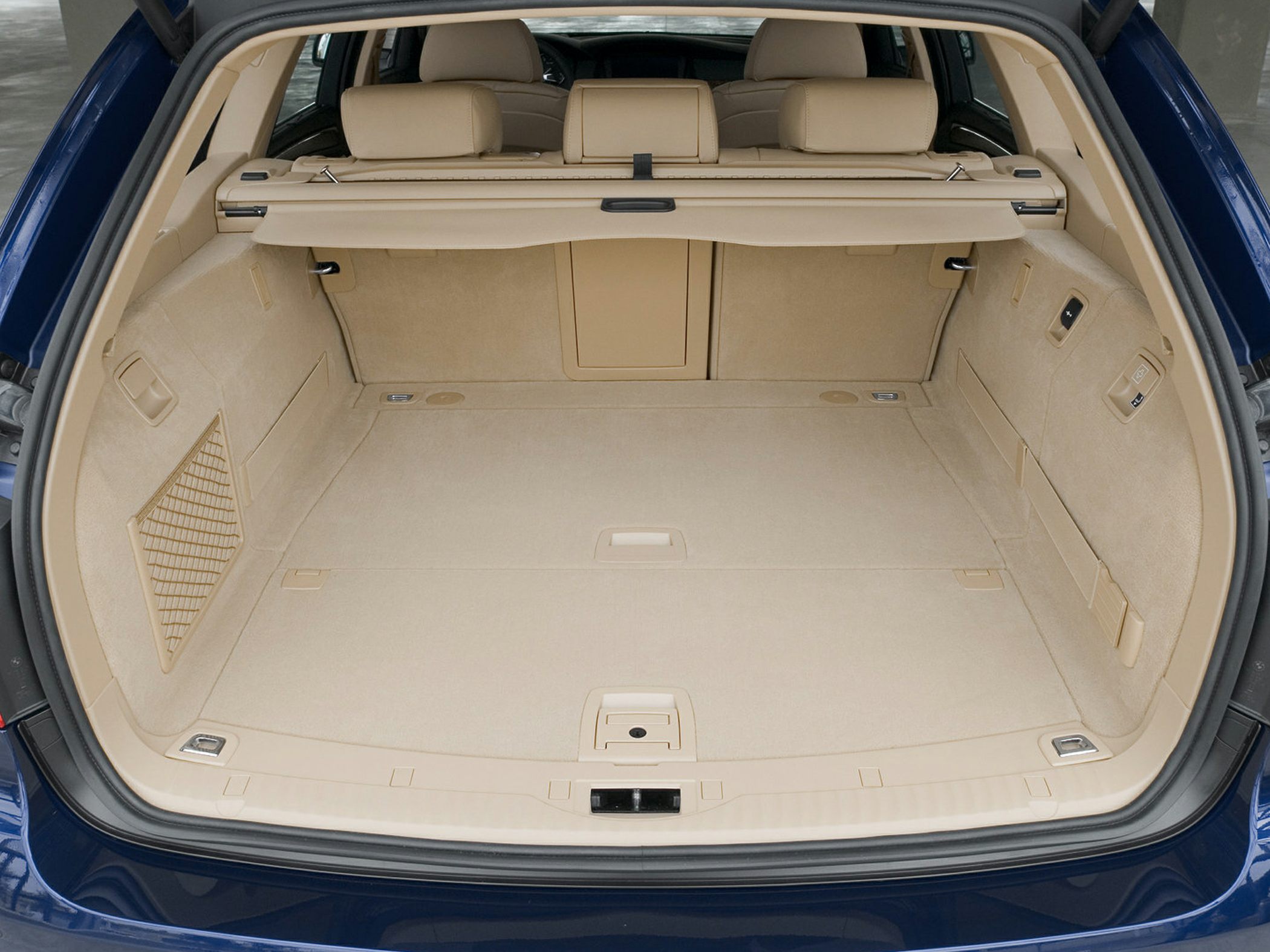 Beige spacious rear cargo area with storage compartments and retractable cover