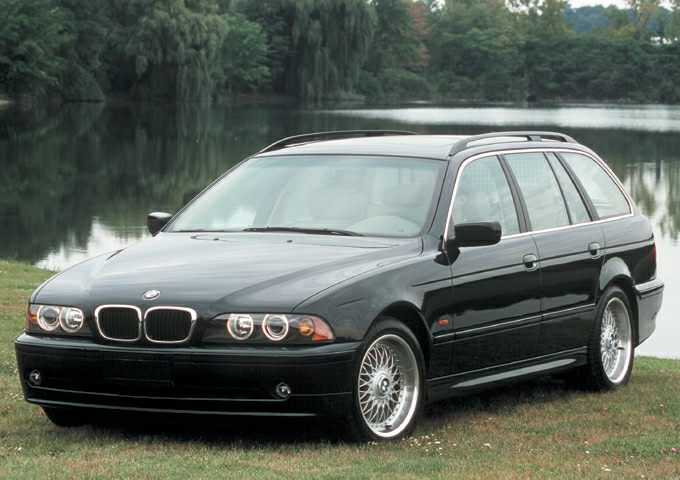 Black station wagon with dual round headlights and roof rails