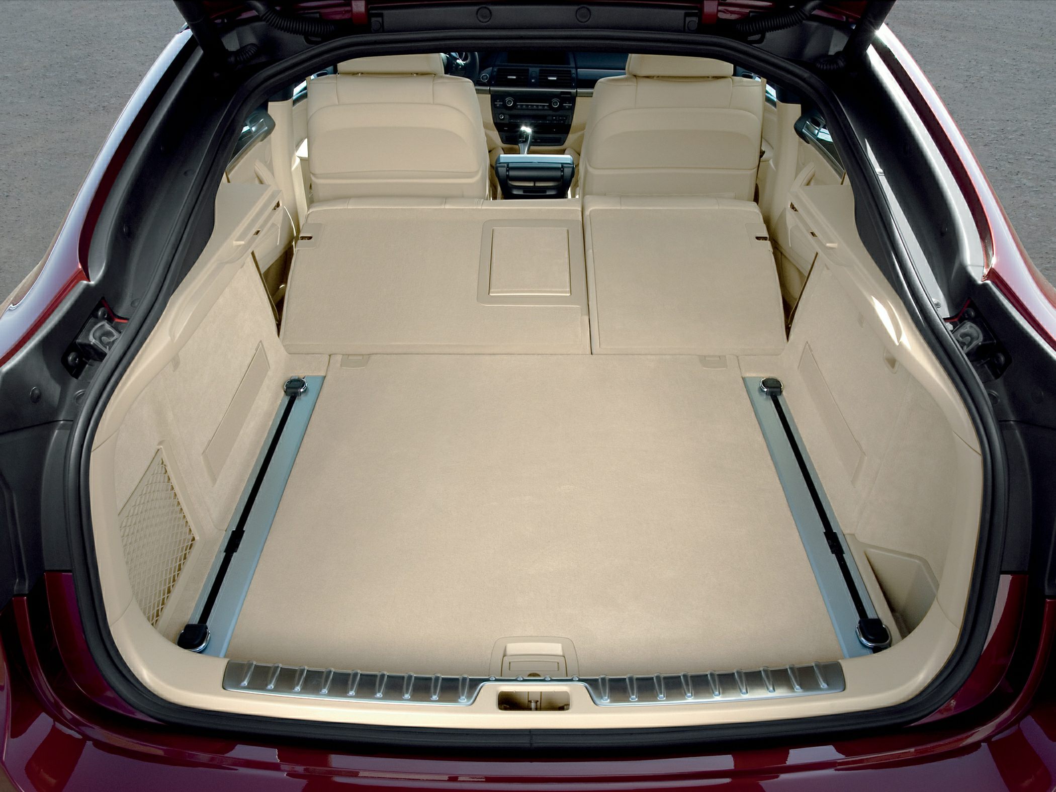 Spacious beige cargo area with folded rear seats and metal cargo rails
