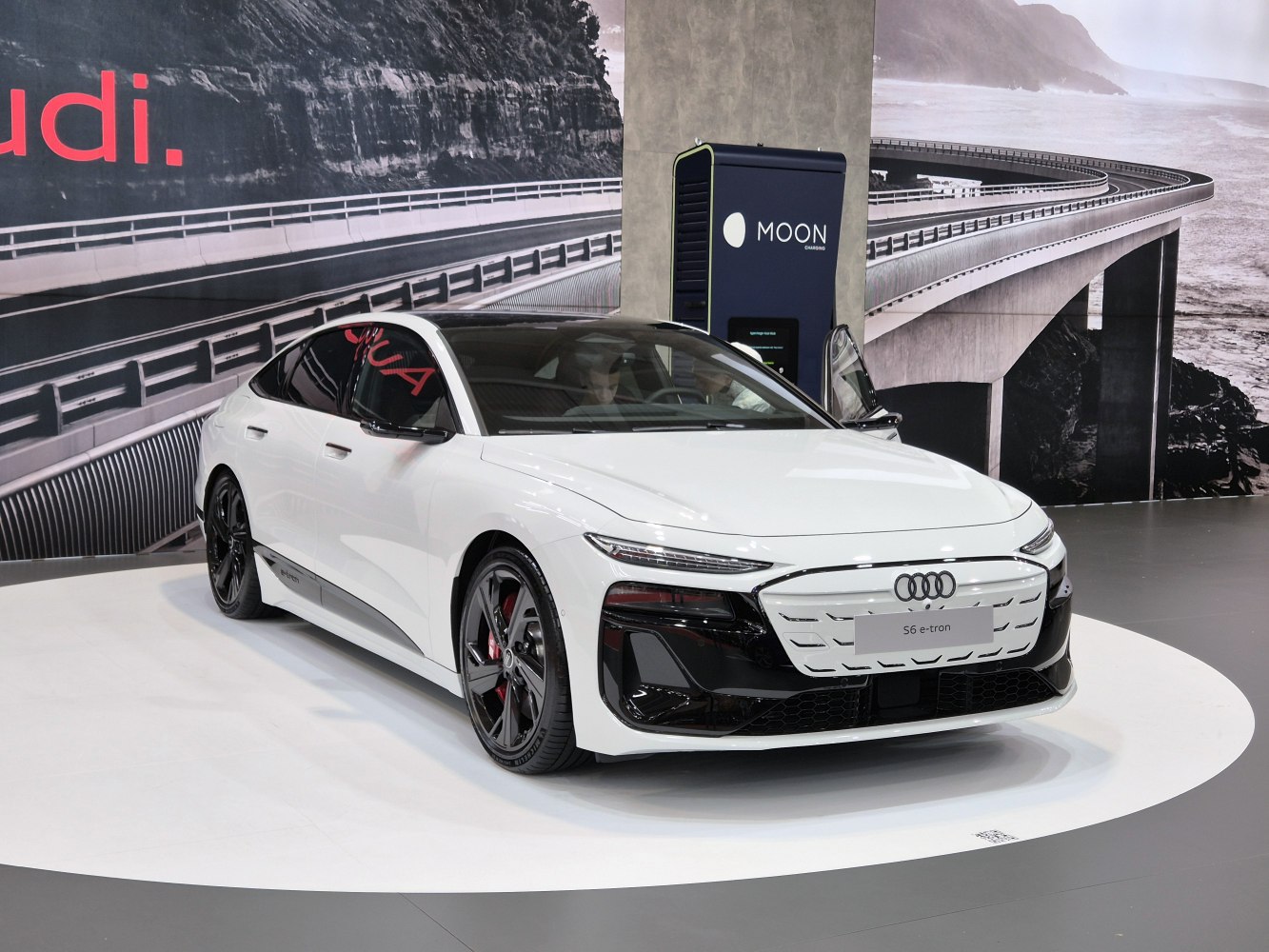 White electric sedan with sharp LED headlights and black grille accents