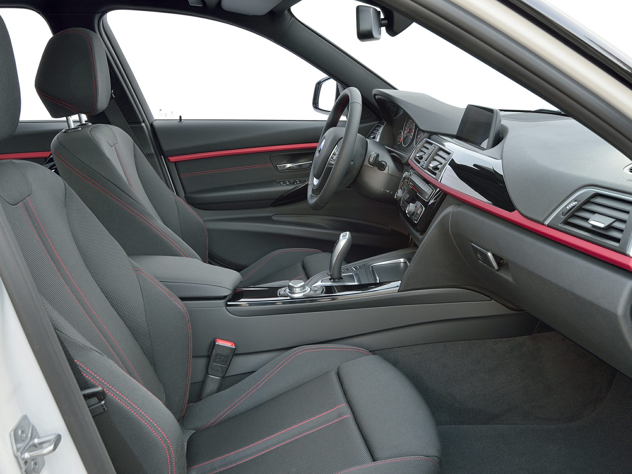 Modern dashboard and front seats with red stitching.