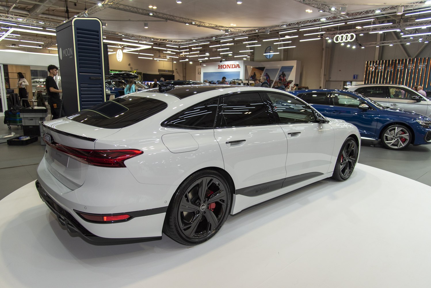 Rear and side view of a sleek electric sportback with black wheels