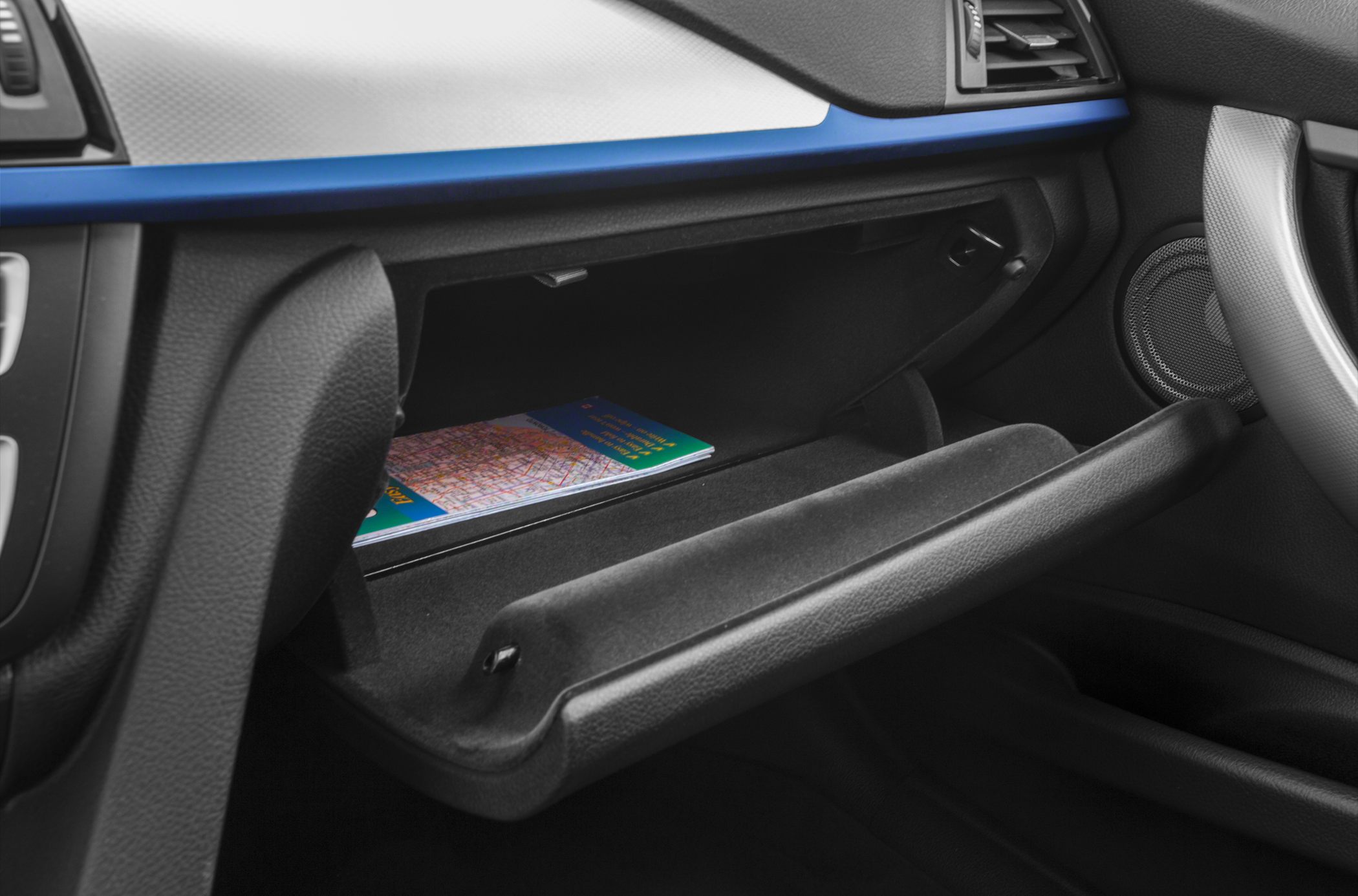 Open glove compartment with map inside and detailed dashboard trim