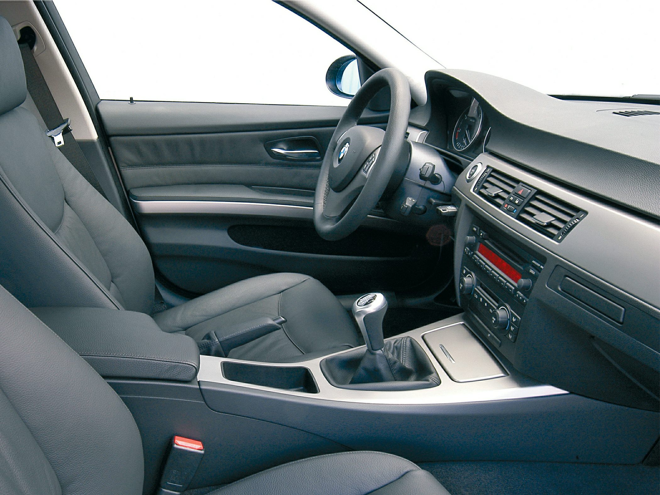 Car interior with black leather seats and manual gear shift.