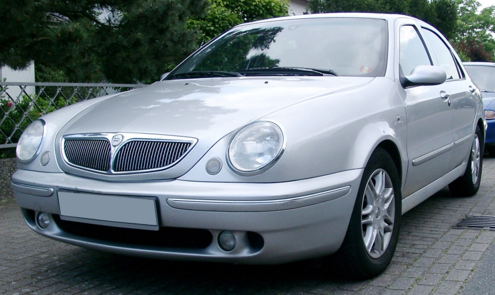 Front view with oval headlights and chrome grille on silver sedan