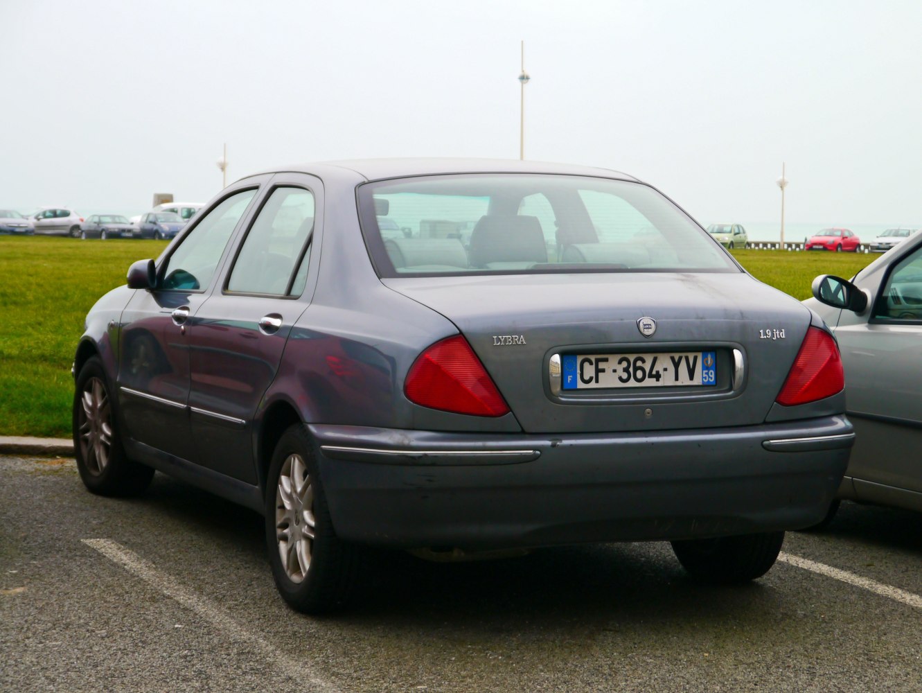 Rear view of mid-size sedan with triangular tail lights and rounded rear design.