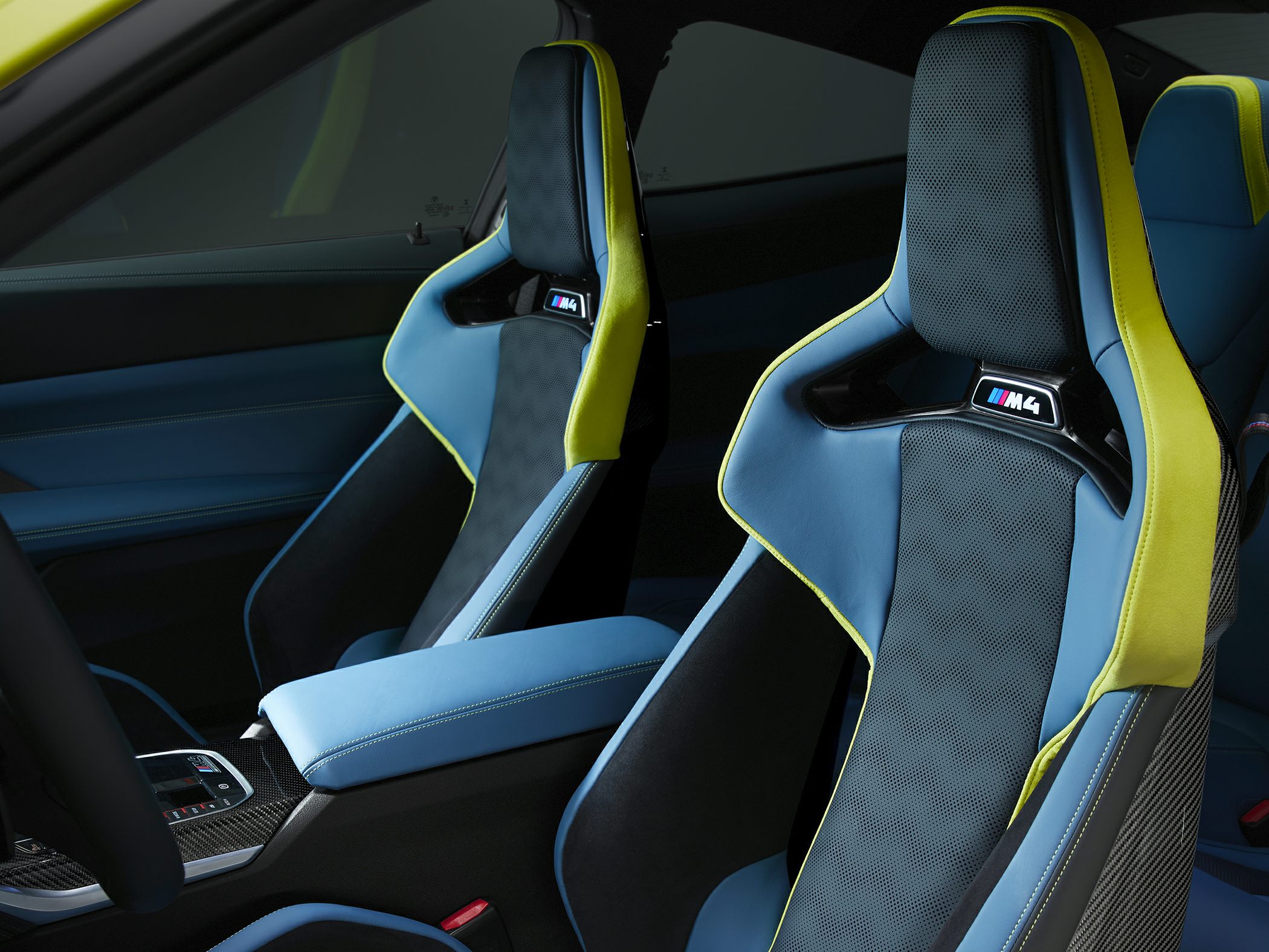 Sport bucket seats with blue upholstery and yellow trim, carbon fiber backing