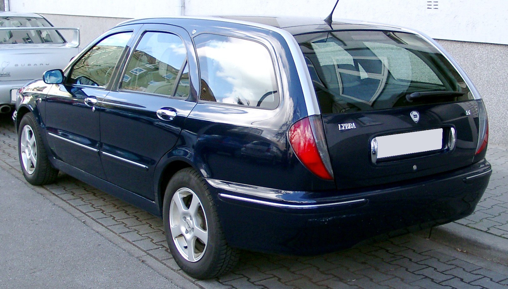 Rear side view of a station wagon with distinct taillights and dark blue finish
