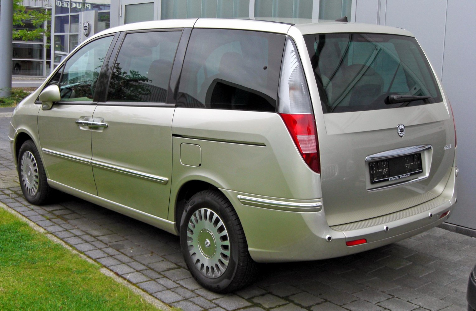 Rear and side profile of a sleek MPV with large rear window and distinct rear light cluster