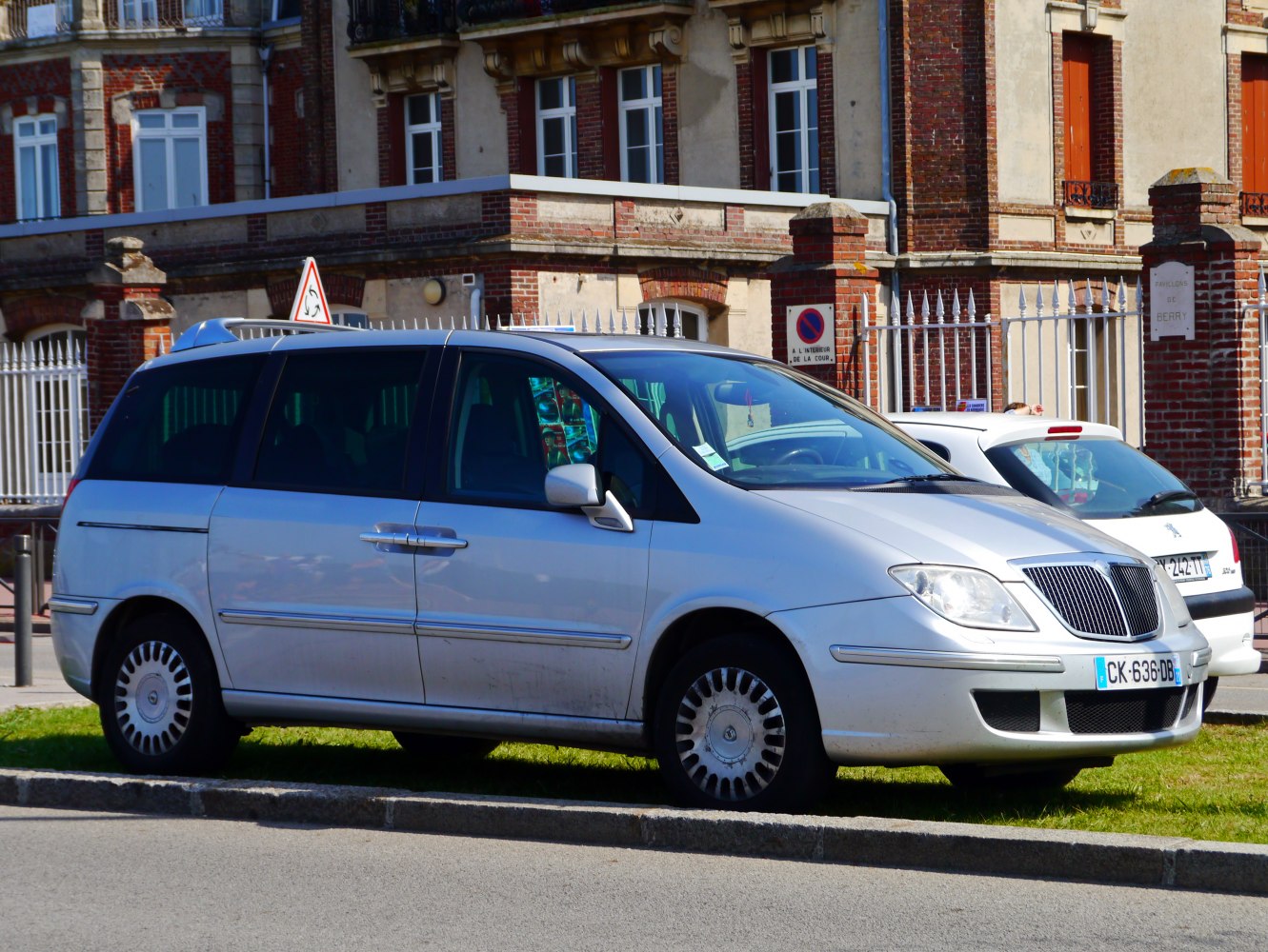 Side view of silver minivan with sliding rear door and alloy wheels