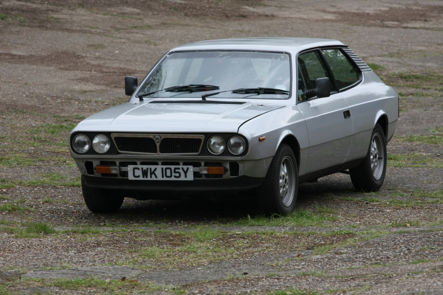 Front view of classic coupe with quad headlights and slatted rear window