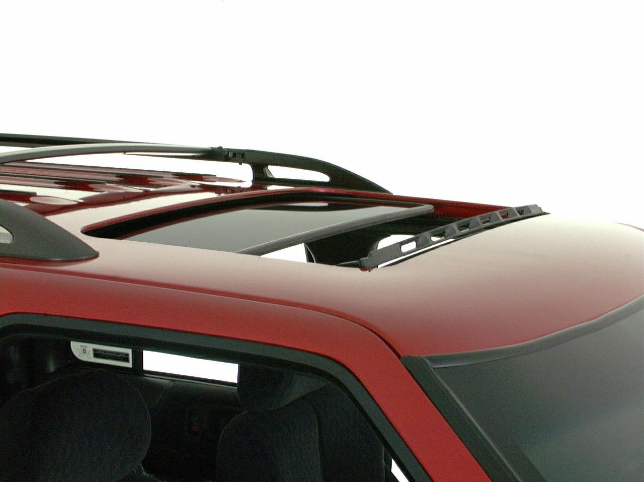 Open sunroof and roof rails on a red SUV roof.