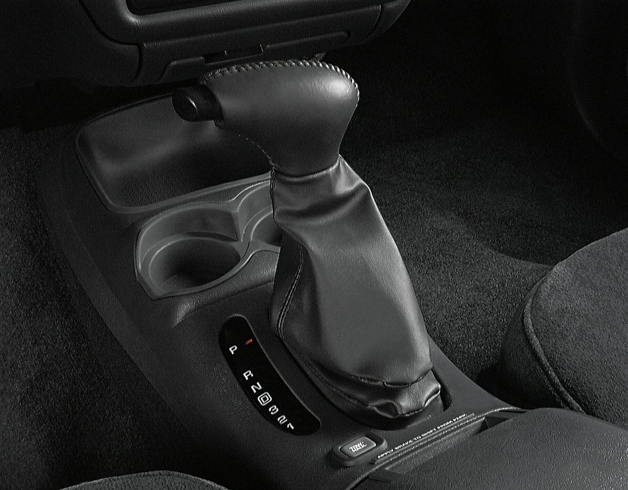 Automatic gear shift lever with center console and cup holders.