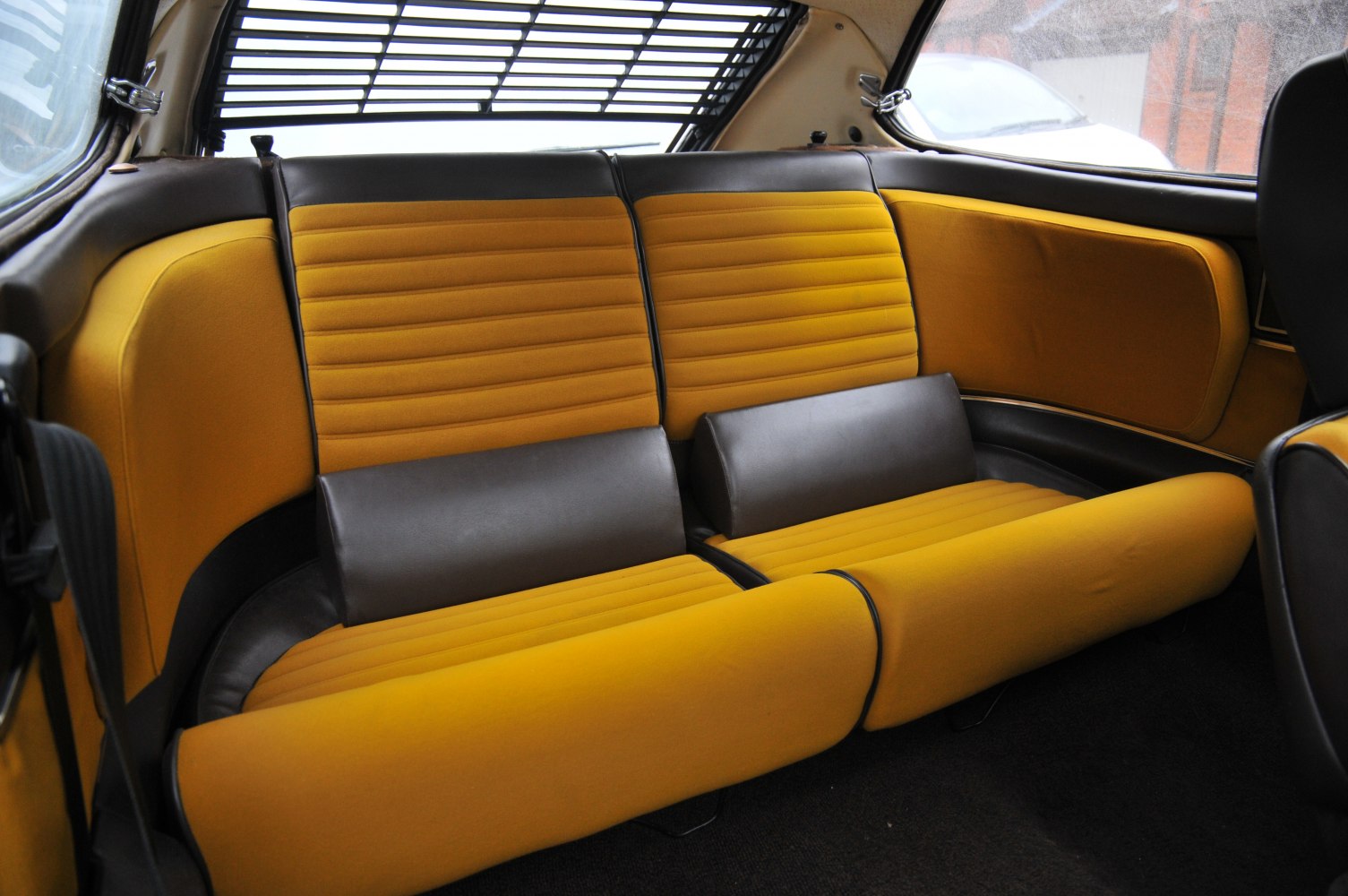 Two-tone yellow and brown rear seat upholstery in a vintage coupe