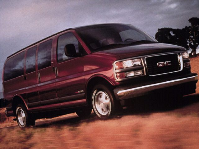 Large full-size van in motion with sliding side doors and chrome bumper