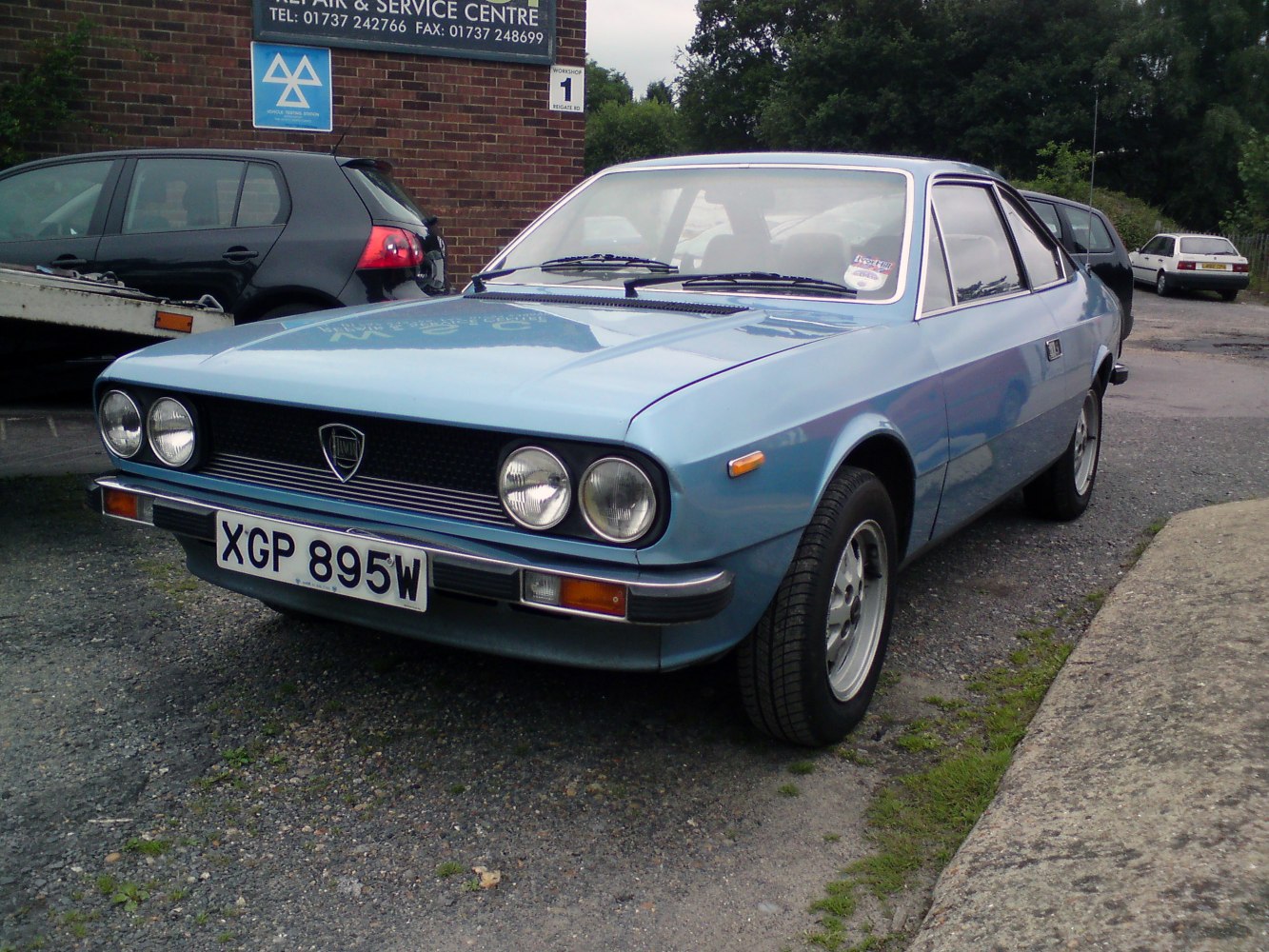 Front-side view of classic coupe with quad round headlights and angular design