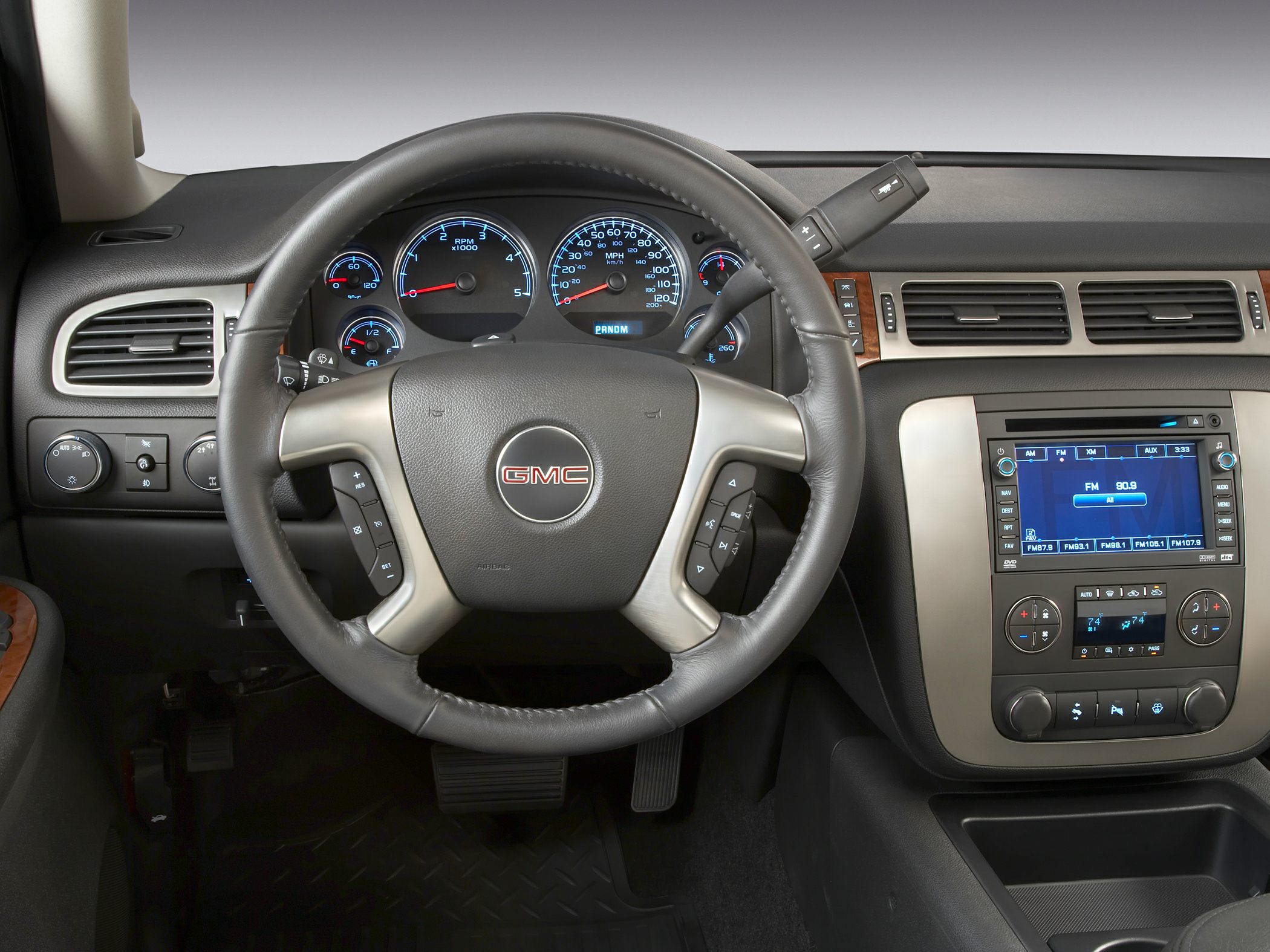 Steering wheel and dashboard with instrument cluster and infotainment controls