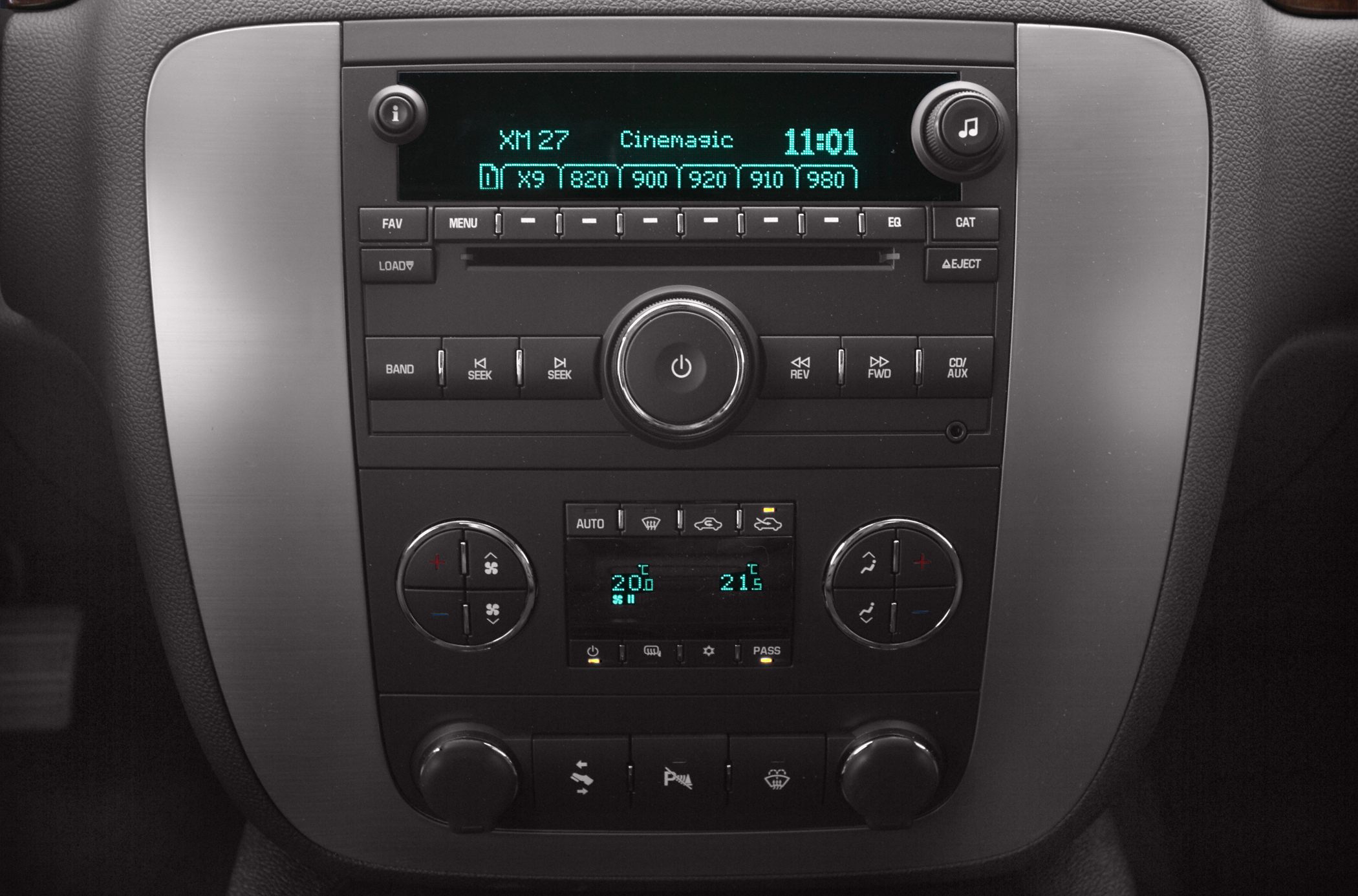 Car radio and dual-zone climate control panel with digital display and control knobs.