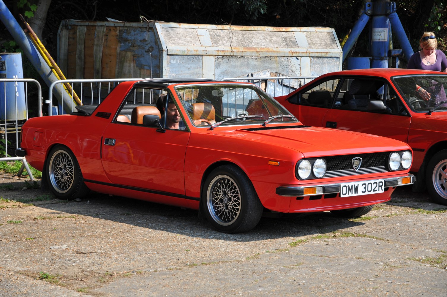 Sporty red targa coupe with quad headlights and mesh alloy wheels