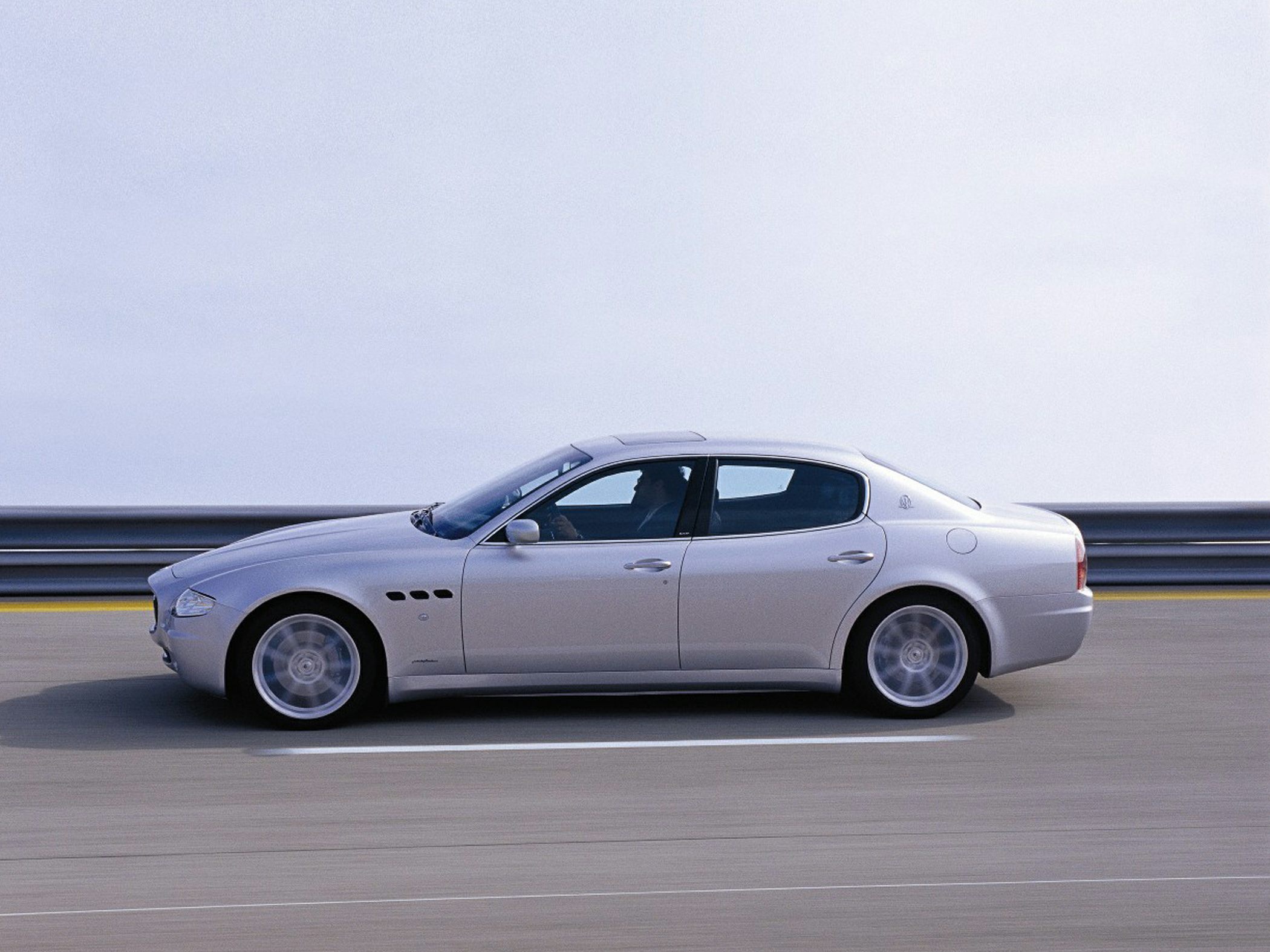Silver four-door sedan side profile with aerodynamic shape and alloy wheels.