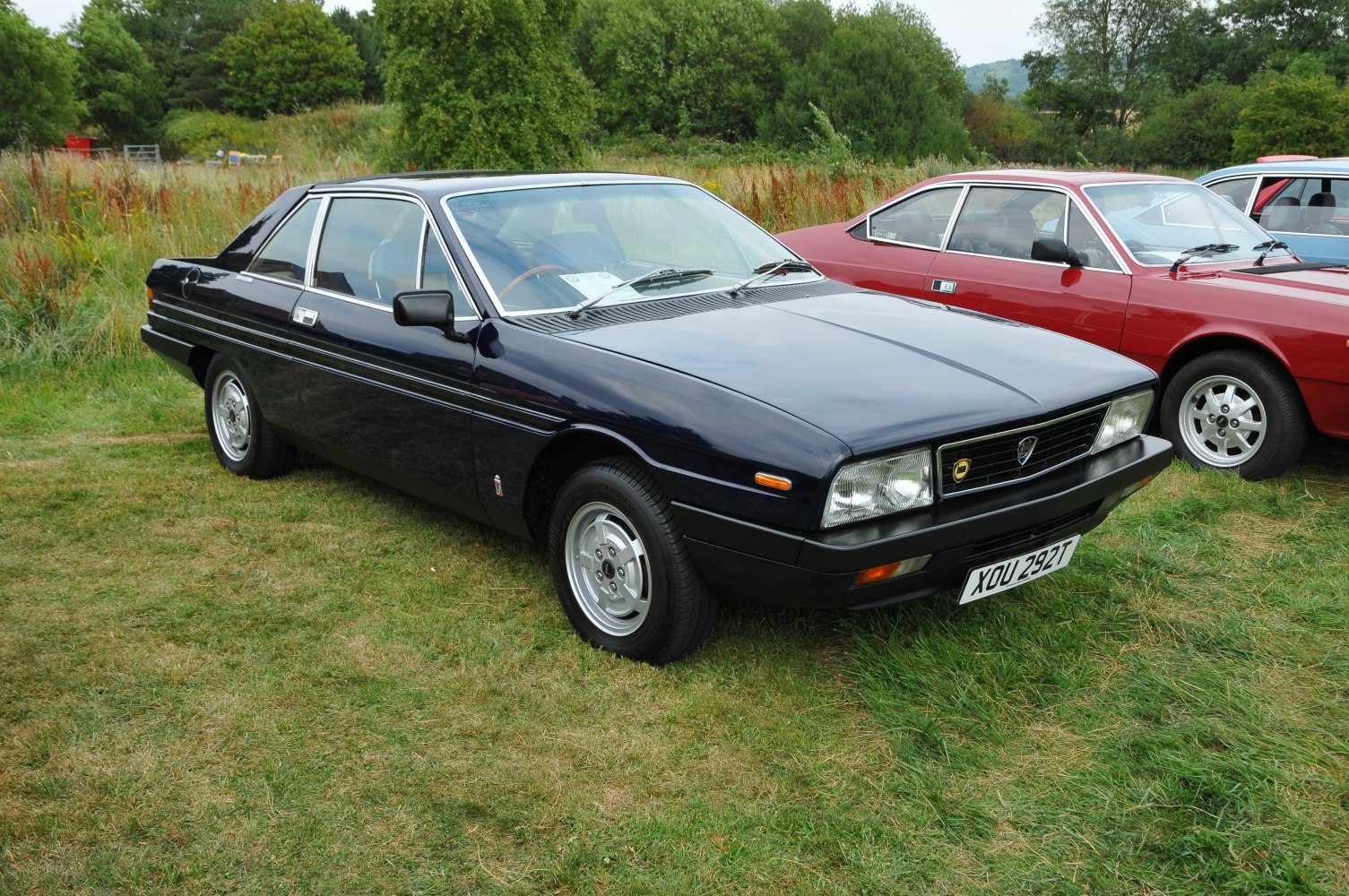 Front side view of angular vintage coupe with chrome trims and distinctive wheels