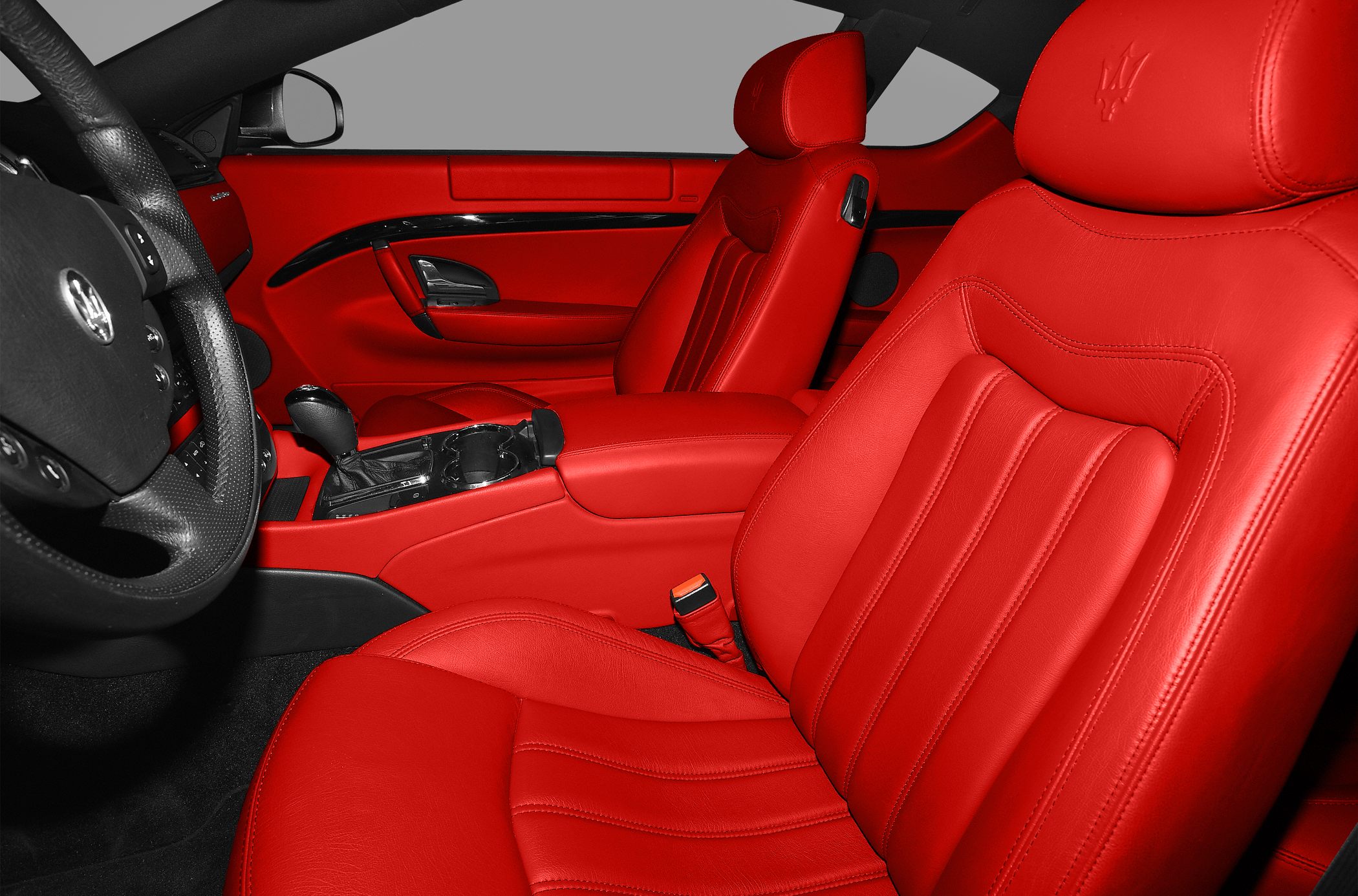 Red leather front seats and door panel with detailed stitching and ergonomic design